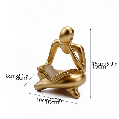 Golden glossy abstract thinker resin figurine showing a seated thinker holding a book for office decorbites decor