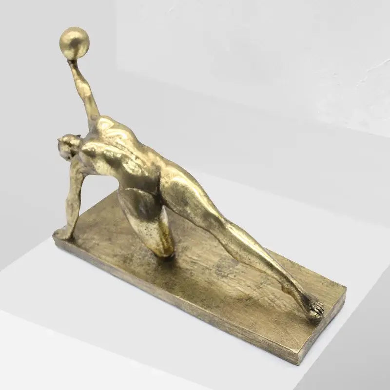 Decorbites golden gymnast metallic sculpture in a dynamic yoga pose holding a ball for living room decor