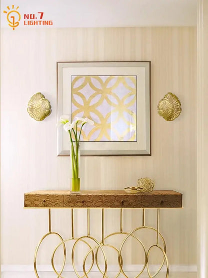 Gold leaf patterned console table with circular metal legs and textured wood top complements decorbites designer copper wall lamp