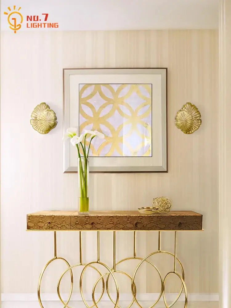 Gold leaf patterned console table with circular metal legs and textured wood top complements decorbites designer copper wall lamp