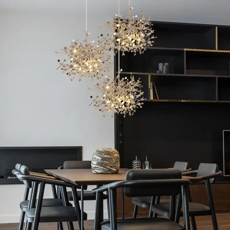 Three elegant gold-toned leaf pendant lights with intricate branch designs hang above a dining table decorbites g9 leaf
