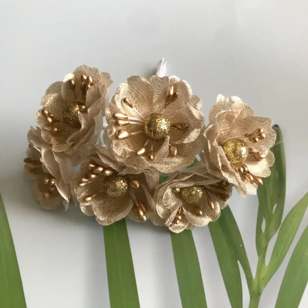 Delicate beige fabric flowers with gold glitter centers and berry stamen metallic accents for decorbites green plant decor