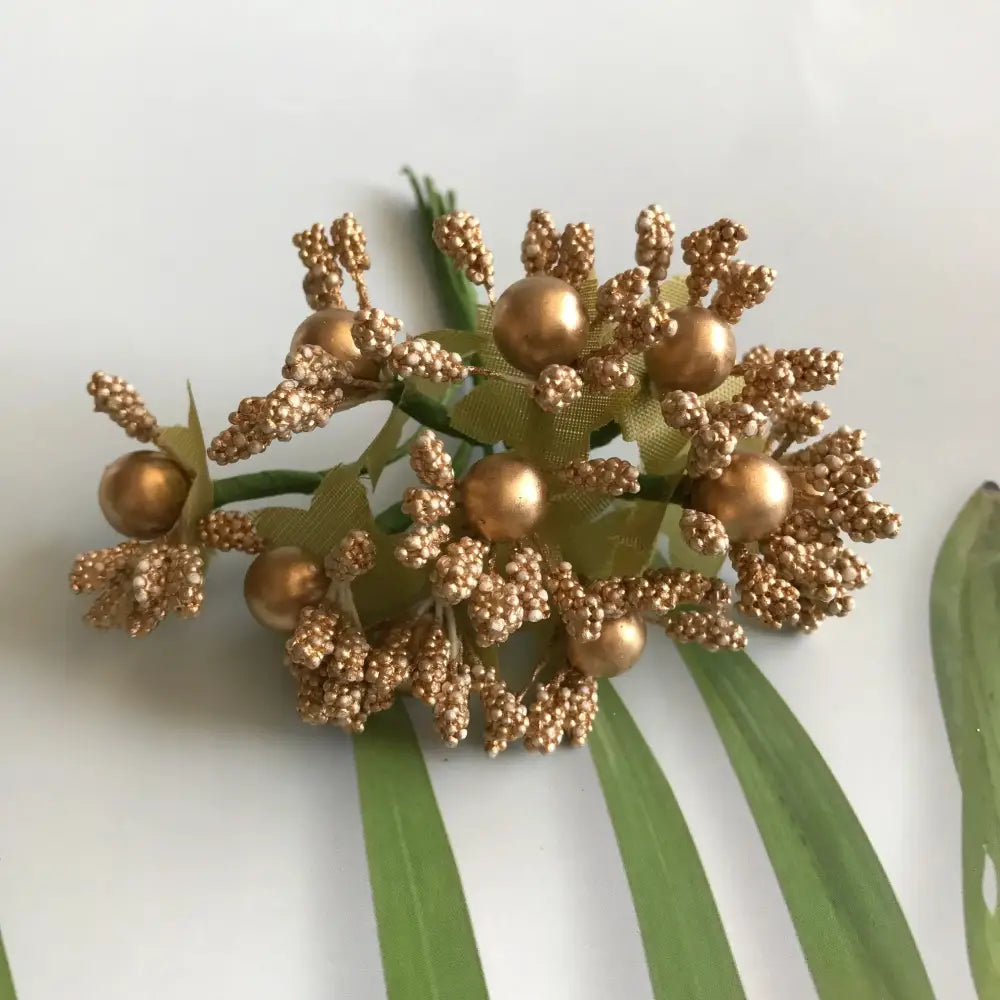 Golden metallic berry stamen green plant with textured buds and glossy spheres for living room decor by decorbites