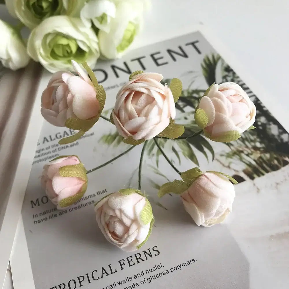 A delicate cluster of pink fabric roses with green ribbon accents and golden metallic berry stamen green plant decorbites green plant decor