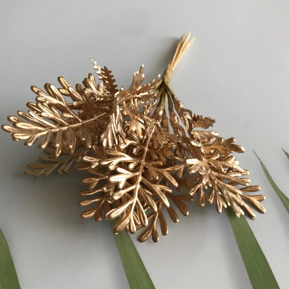 Golden metallic fern brooch with intricate leaf detailing and tied stem for decorbites green plant berry stamen decor