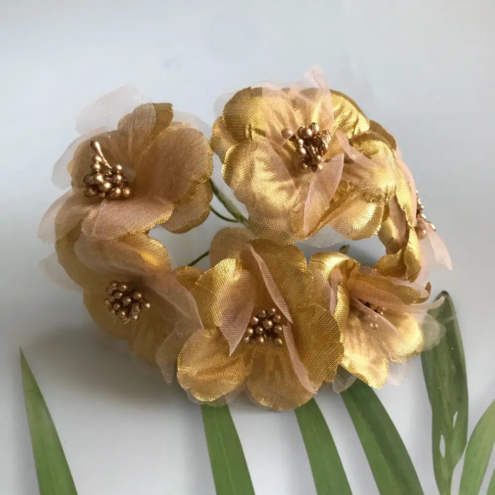 A delicate cluster of golden fabric flowers with berry stamen and green plant foliage for decorbites green plant decor