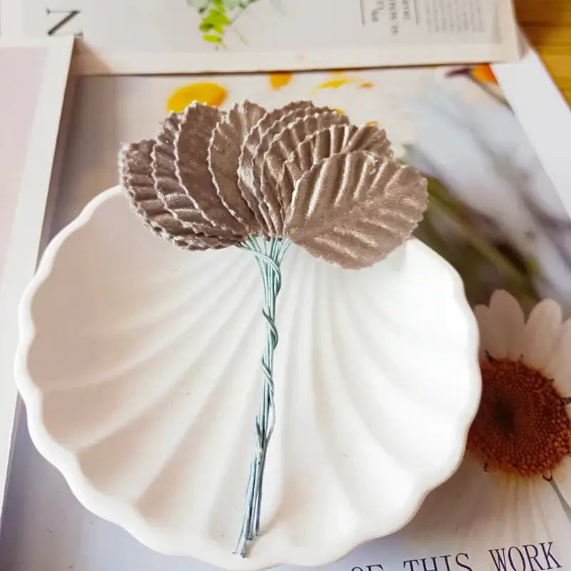 A delicate metallic bronze artificial flower with ruffled petals and twisted wire stem for decorbites green plant decor