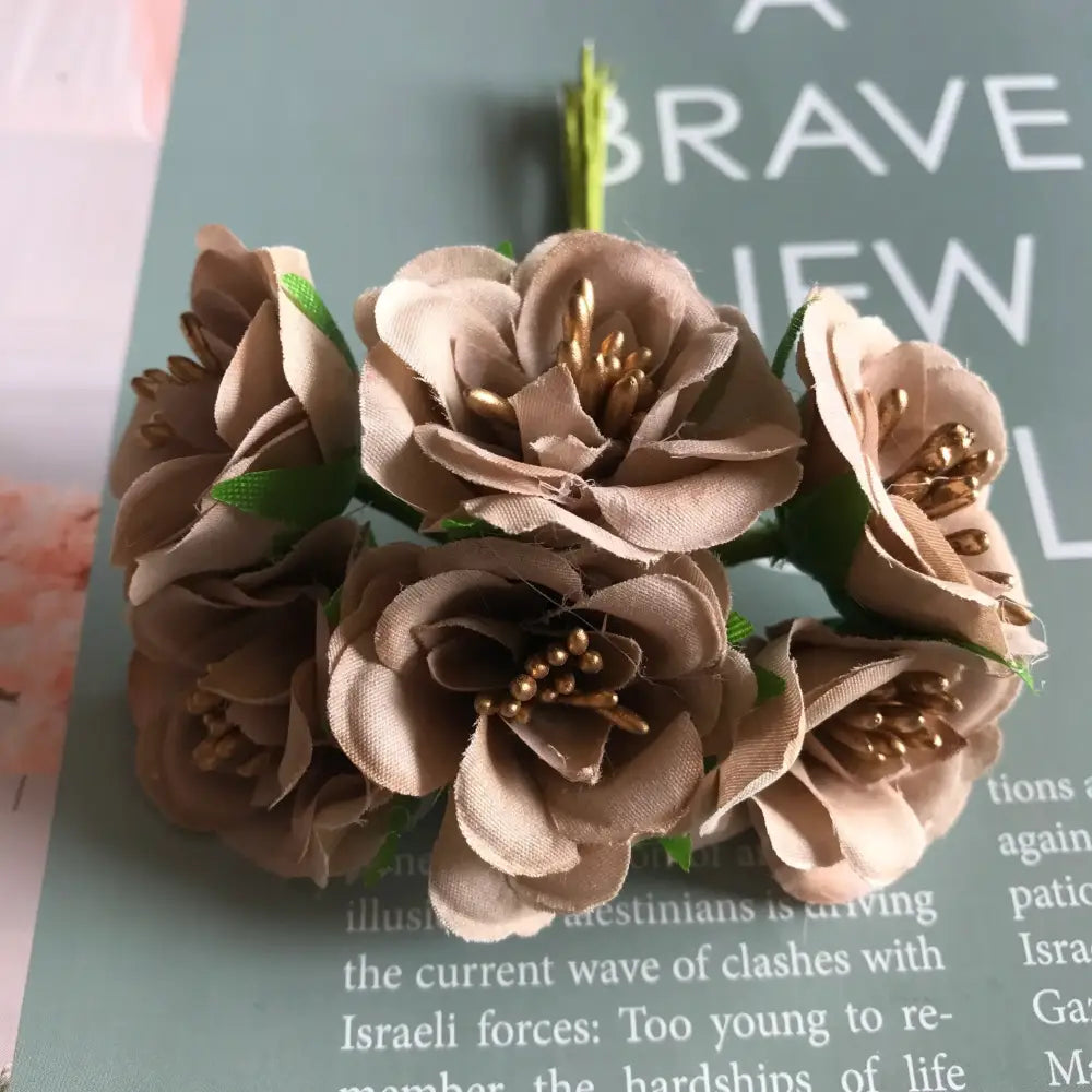 A delicate cluster of beige fabric roses with gold berry stamen and green stems for decorbites green plant decor