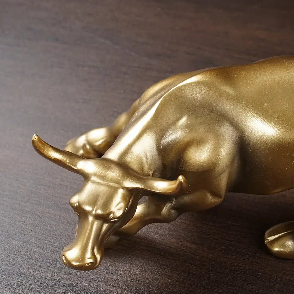 Golden metallic bull figurine with detailed musculature and prominent horns for living room feng shui decor by decorbites