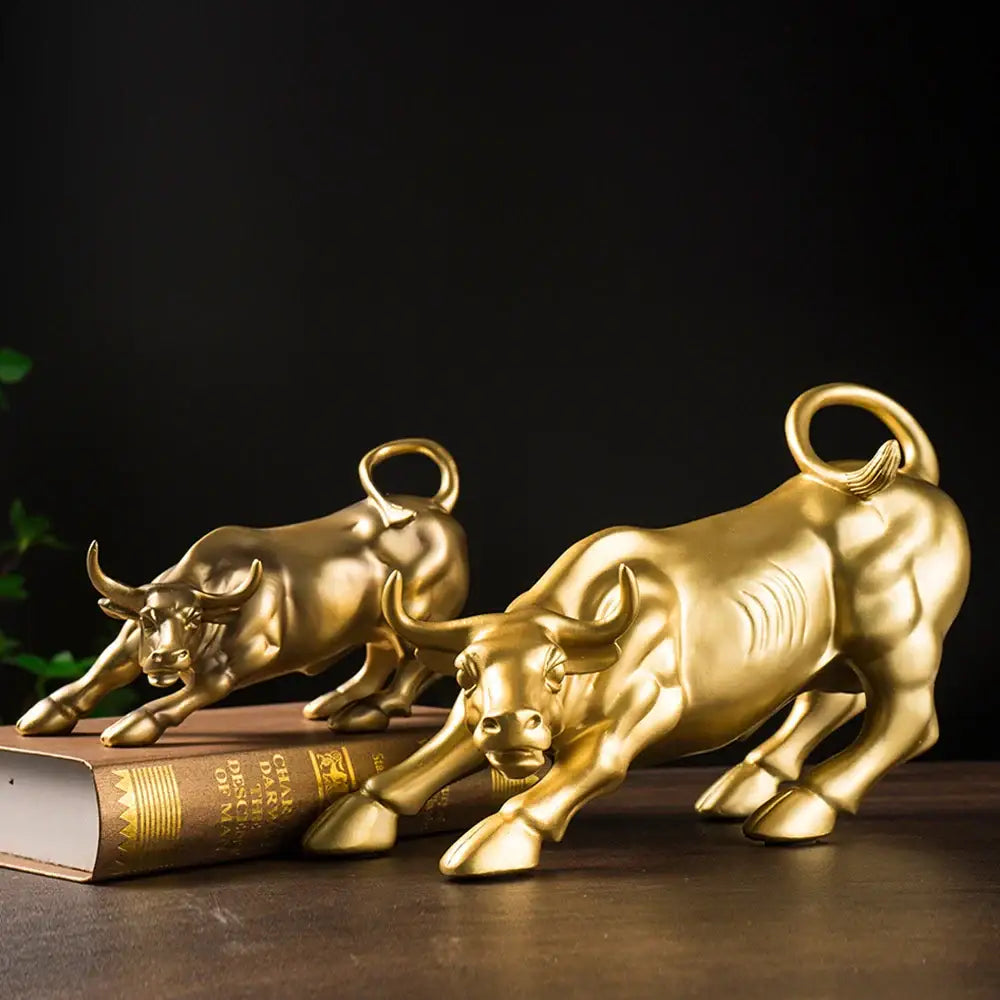 Two golden glossy resin bull figurines with detailed musculature and curled tails for living room feng shui decorbites bull figurine