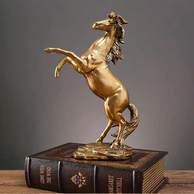 Golden metallic horse resin sculpture by decorbites with detailed mane and tail standing reared on textured base for decor