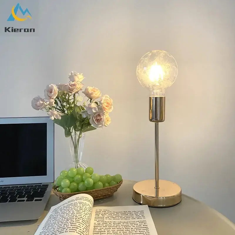 Golden modern led bedside lamp with clear textured glass bulb and sleek cylindrical base for bedroom lighting