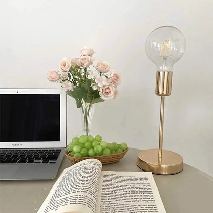 Golden modern led desk lamp with gold-toned slender stem and clear glass bulb for elegant bedroom decorbites desk lamp