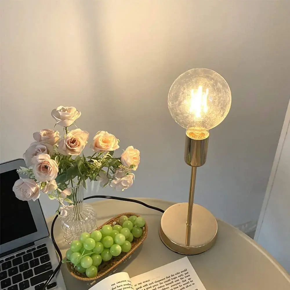 A decorbites golden modern led desk lamp with warm-glowing textured glass globe and sleek gold-toned metal base