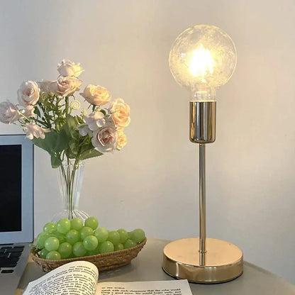 A decorbites golden modern led desk lamp with a warm textured glass globe and sleek brass-finished base for bedroom decor