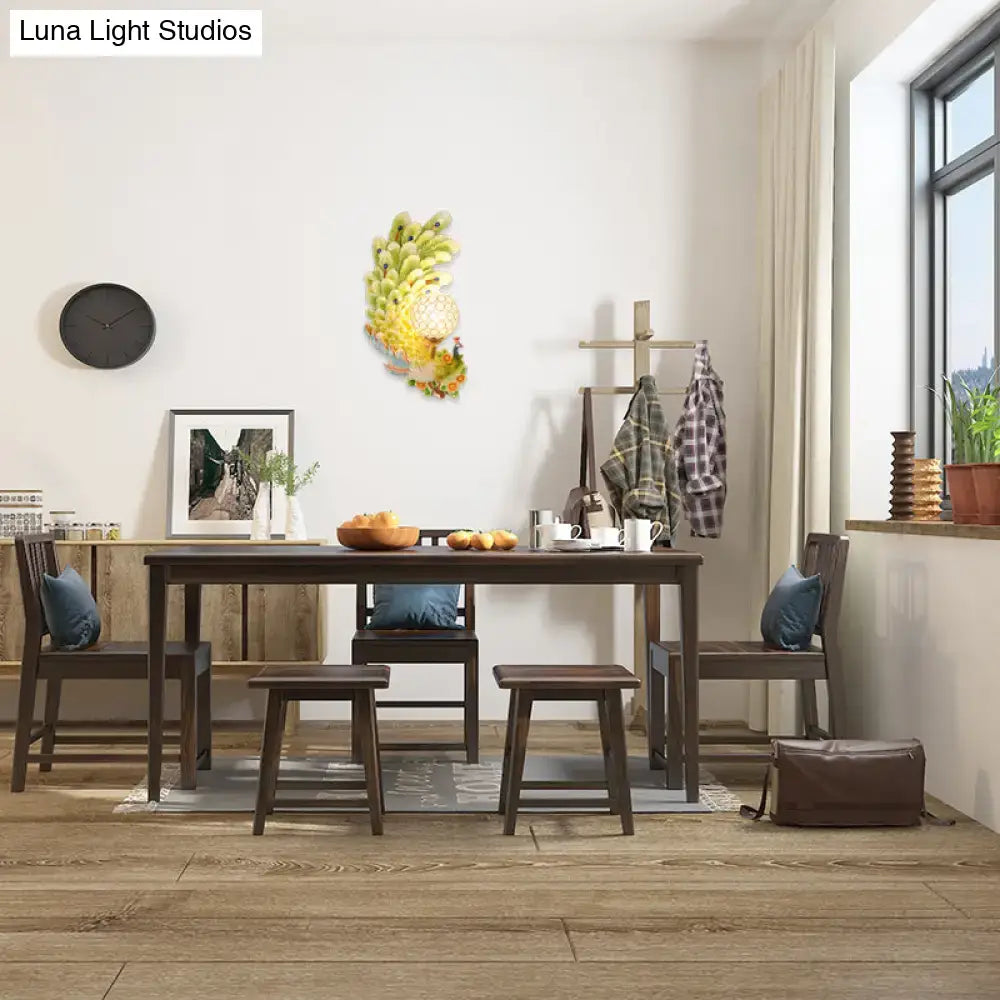 Golden peacock wall light with crystal shade and yellow green banana-themed wall art above dining table