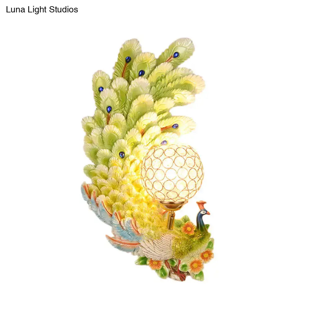 Golden peacock wall light with crystal shade featuring yellow green feathers and orange floral accents for living room use