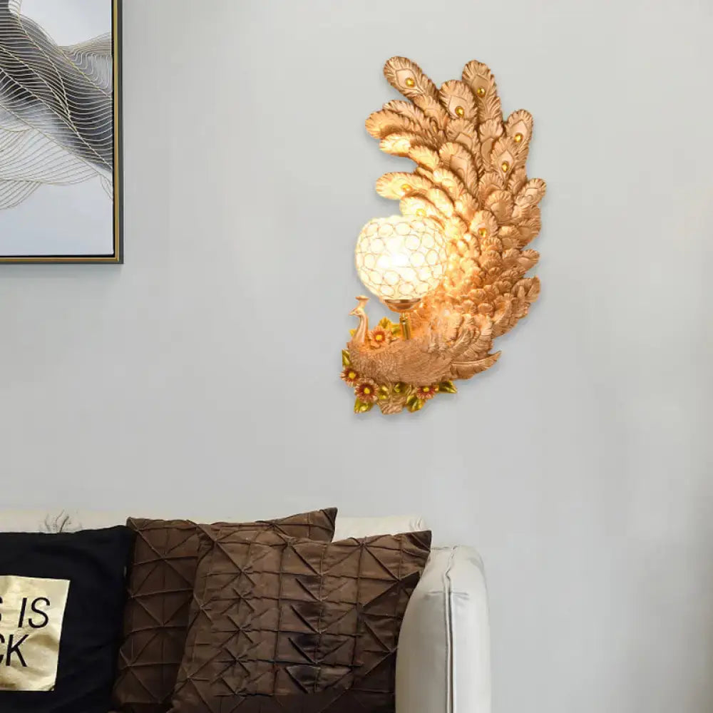 Golden peacock wall light with crystal shade featuring intricate feather details and yellow green illuminated globe for living room