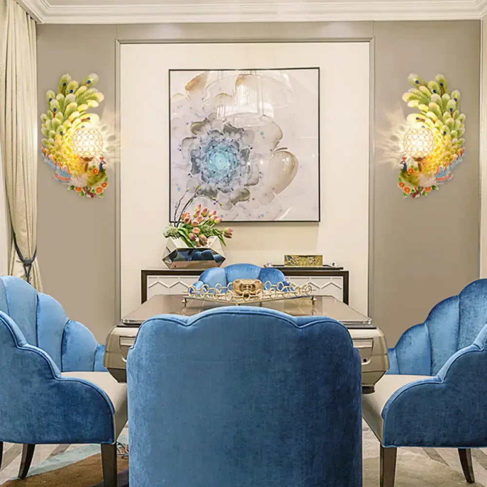Blue velvet armchairs with scalloped backs complement golden peacock wall light with yellow green crystal shade