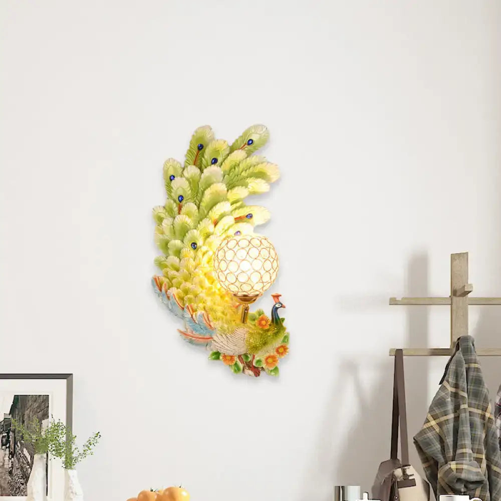 Golden peacock wall light with yellow green iridescent feathers crystal shade and floral accents for living room decor