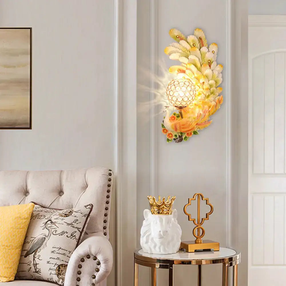 Golden peacock wall light with crystal shade featuring yellow green feathers for elegant living room decor