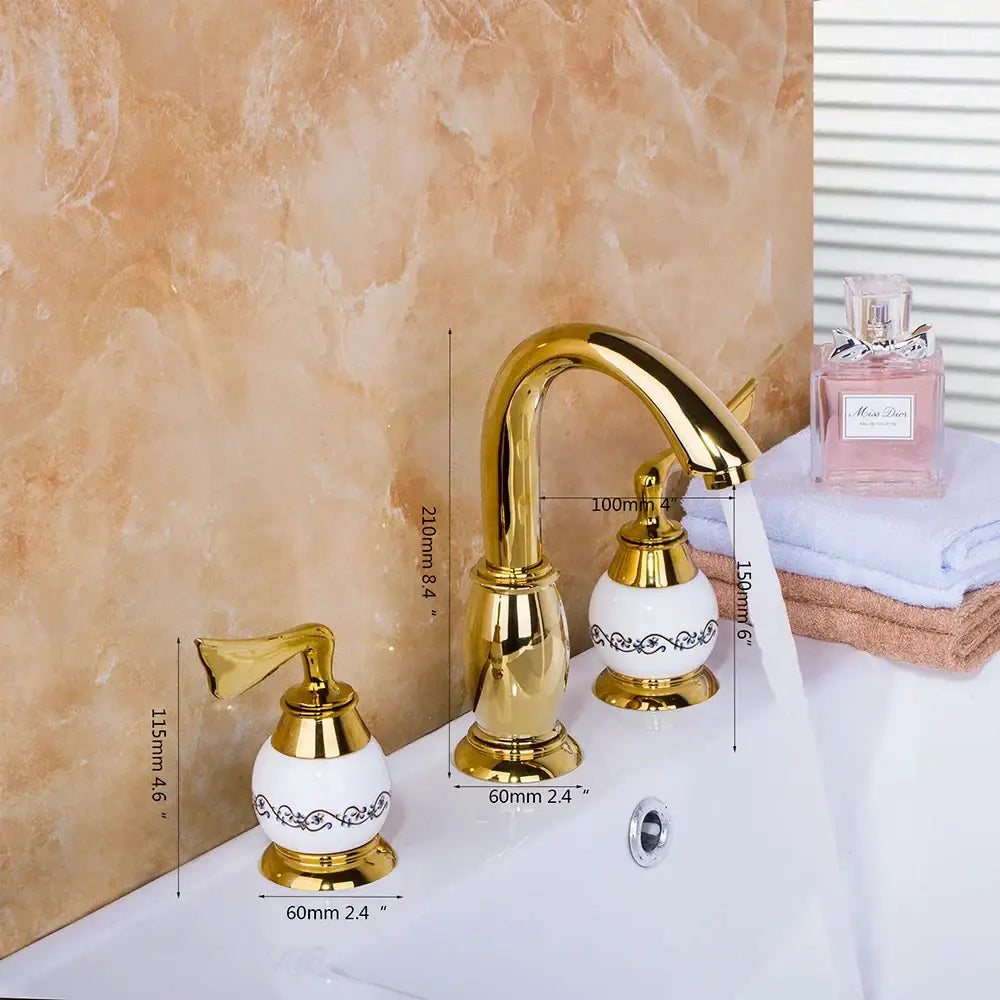 Golden plated bathroom faucet set with gold-finished ceramic and ornate black scrollwork on white porcelain handles decorbites