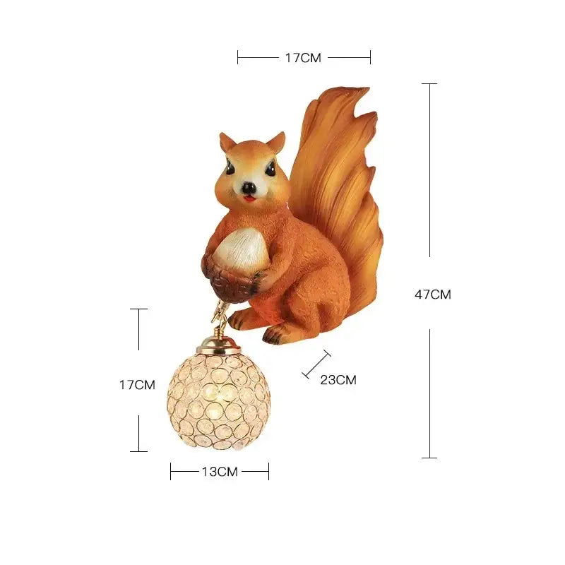 Golden cute squirrel wall lamps with an orange figurine holding an acorn and a crystal globe decorbites cute squirrel lamp