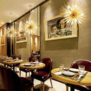 Golden starburst ball pendant lamp with intricate metallic arms radiating light for living room decorbites golden ball