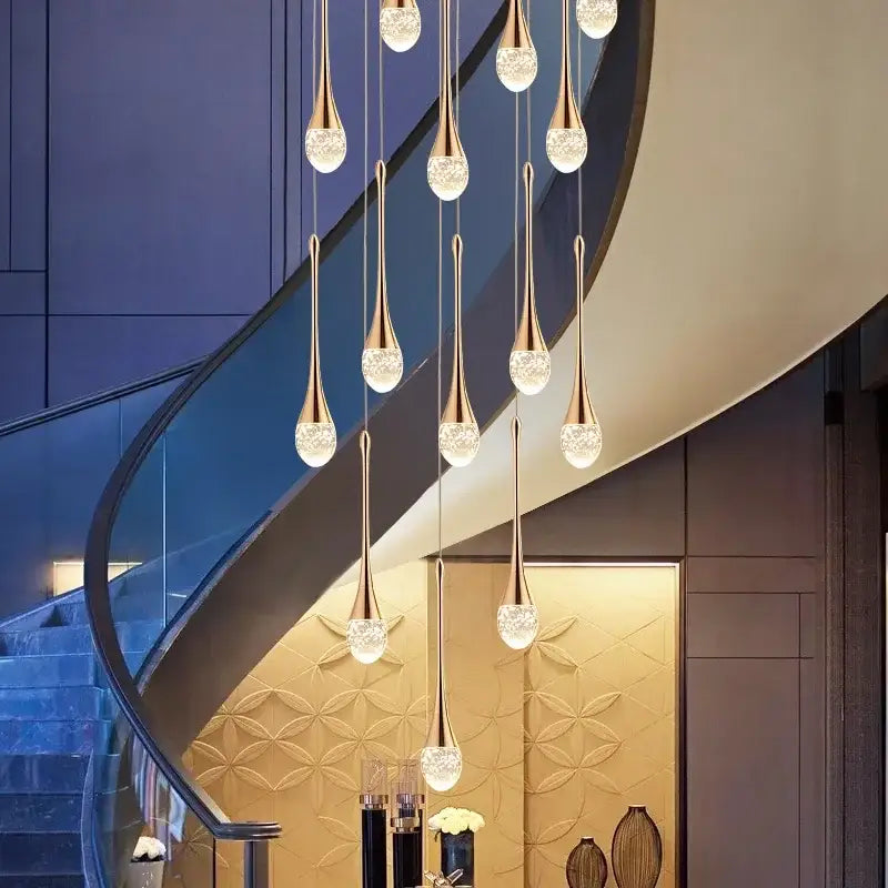 A modern gold-toned pendant light with teardrop crystal globes in a cascading bubble ball design for dining room decorbites crystal bubble