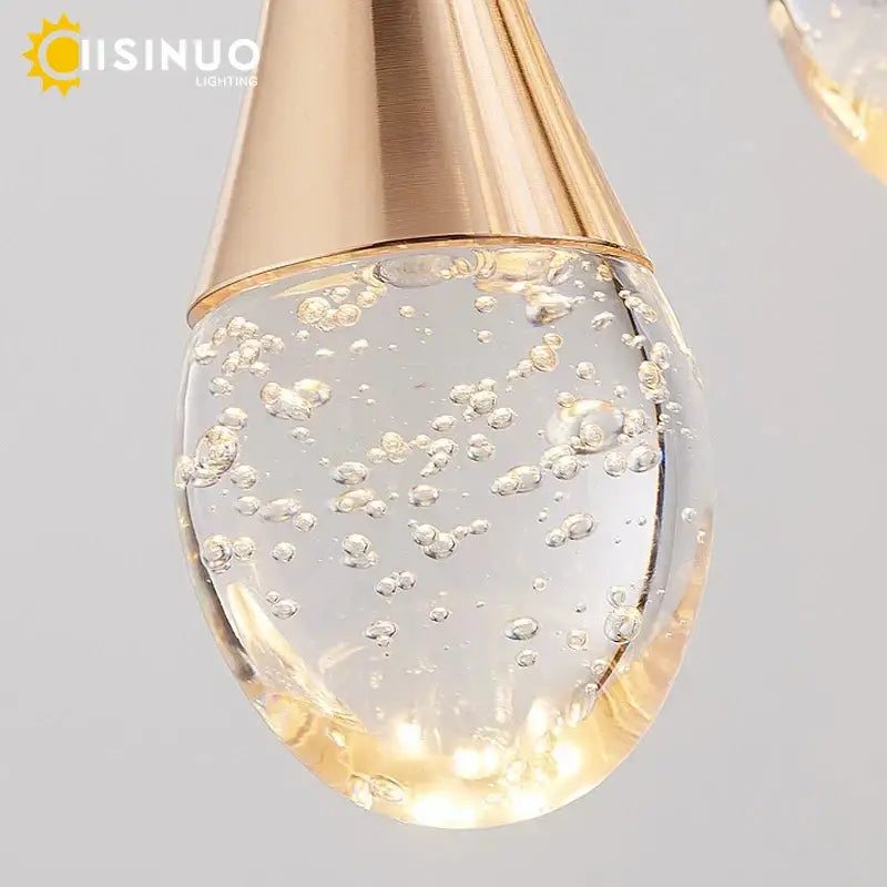 Gold-toned metallic teardrop pendant light with clear glass globe filled with swirling bubbles for decorbites crystal staircase chandelier