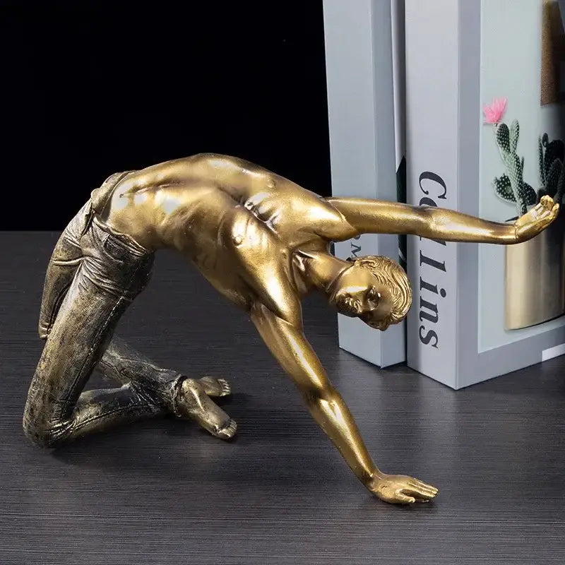 Golden thinker bodybuilder resin sculpture of a man in yoga pose wearing detailed denim pants for office decor