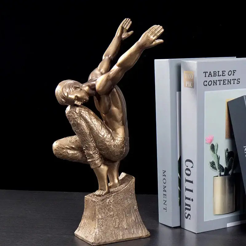 Golden thinker bodybuilder resin sculpture of a metallic figurine in acrobatic pose on a textured tree stump base