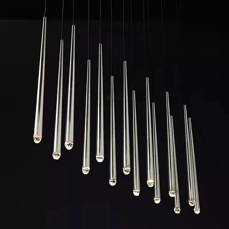 A modern golden water drop ceiling chandelier with slender transparent crystal water drop pendant lights and chrome caps