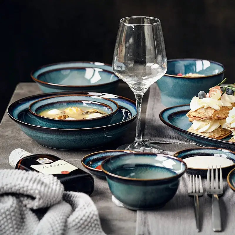 Set of beautiful blue ceramic dinnerware dish and bowl with deep teal glaze and contrasting dark brown rim for dining room