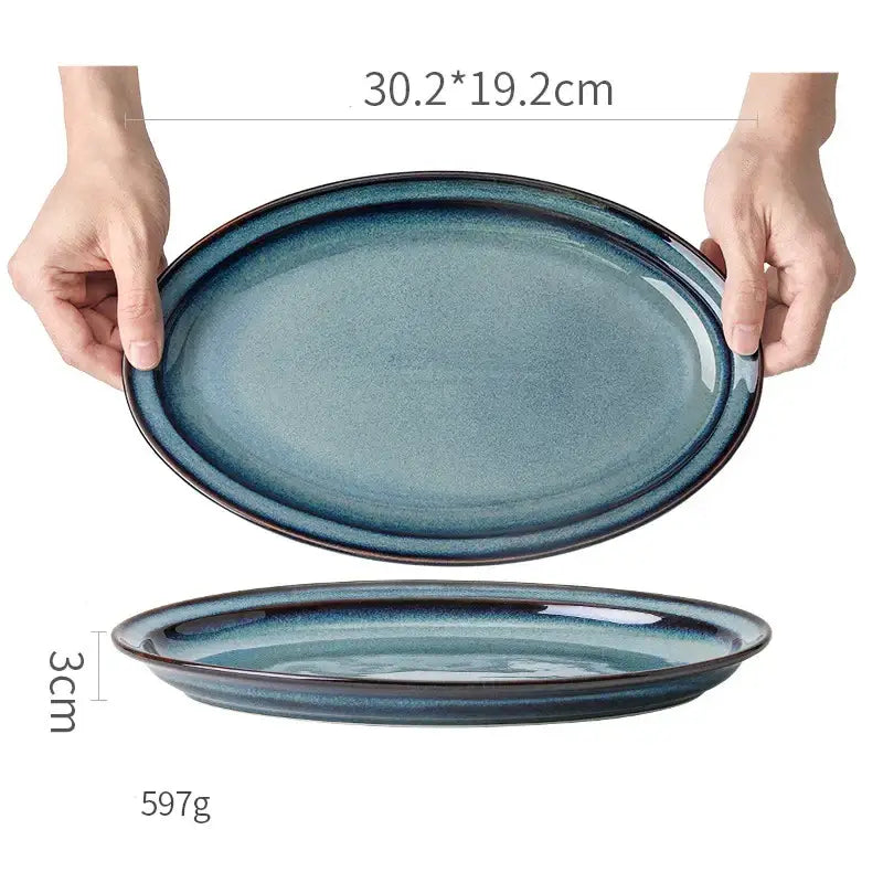 A sleek oval-shaped beautiful blue ceramic bowl with gradient glaze and darkened rim dinnerware dish for dining