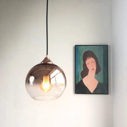 A sleek gradient glass ball chandelier with smoked glass and copper fixture for dining room lighting