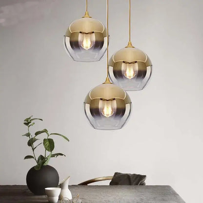 Three modern pendant lights with gold-toned metal frames and gradient glass ball shades for dining room chandelier set