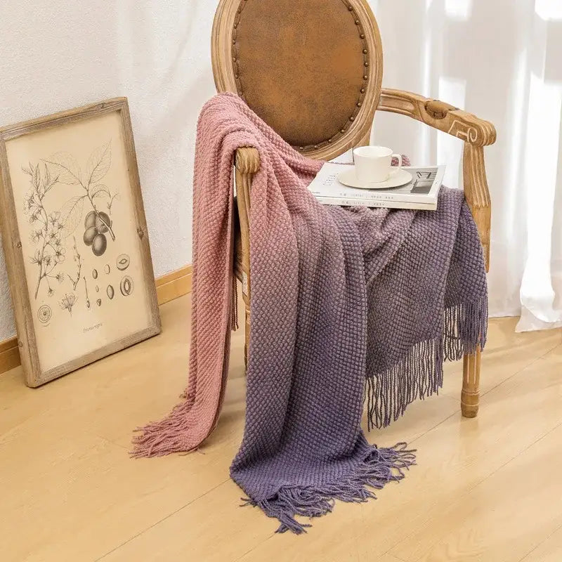 A soft dusty rose and lavender decorbites gradient pineapple knit blanket with textured weave and tasseled throw detailing