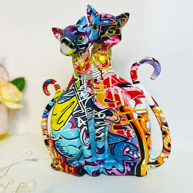 Vibrant graffiti-style decorbites cat couple sculpture featuring stylized cats with gold jewelry and colorful patterns