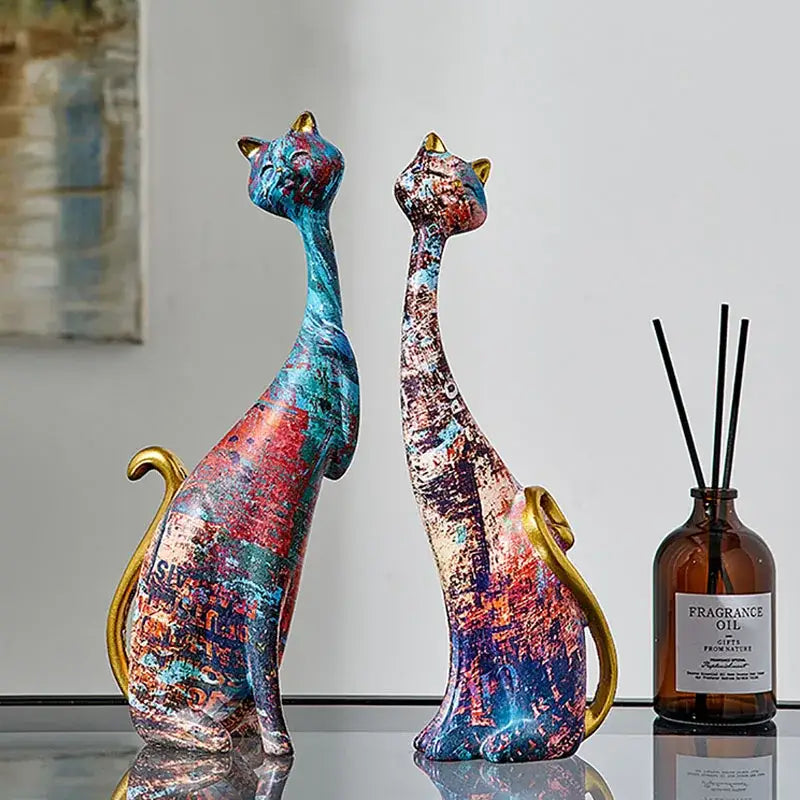 Two cat lovers resin figurines with vibrant blue red purple paint splatter and gold accents for decorbites cat lovers decor