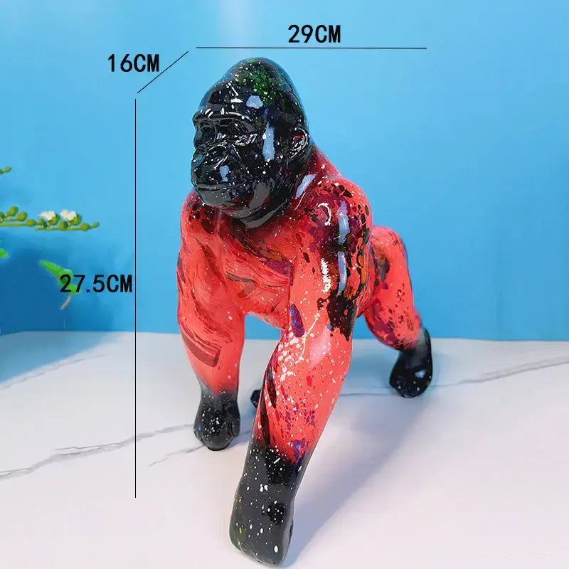 Glossy resin gorilla sculpture with black head and limbs accented by vibrant red paint splatters decorbites gorilla decor