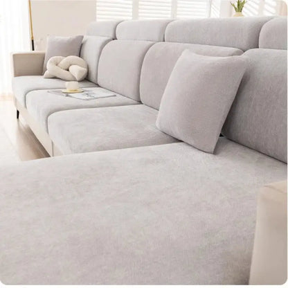 A modern light gray sectional sofa with soft textured fabric and matching pillows featuring a gray and beige chenille sofa cover