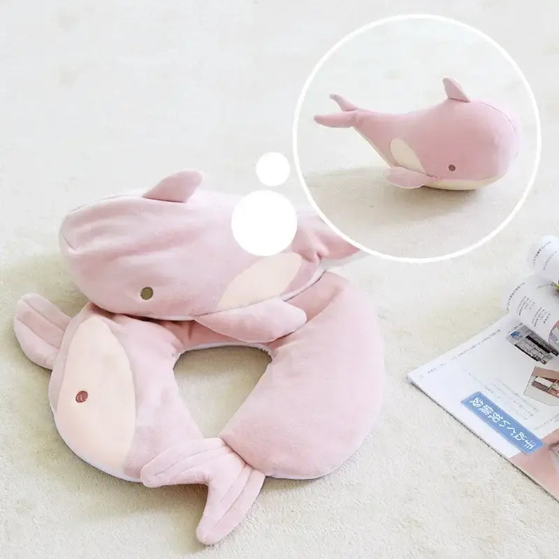 Pink plush dolphin-shaped neck pillow with soft velour texture and embroidered facial details by decorbites cute plush animal