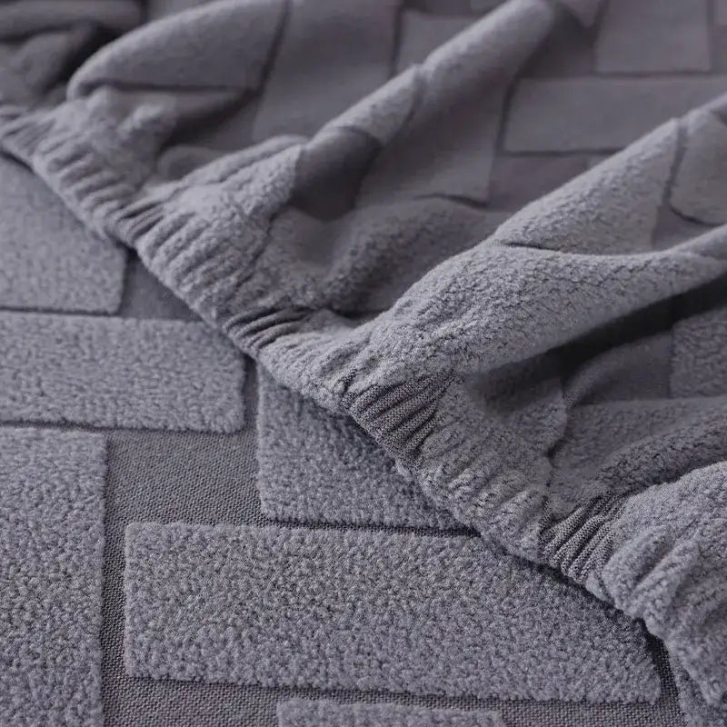 Gray and white woven elastic sofa slipcover with a gray plush towel featuring a textured raised brick pattern for living room