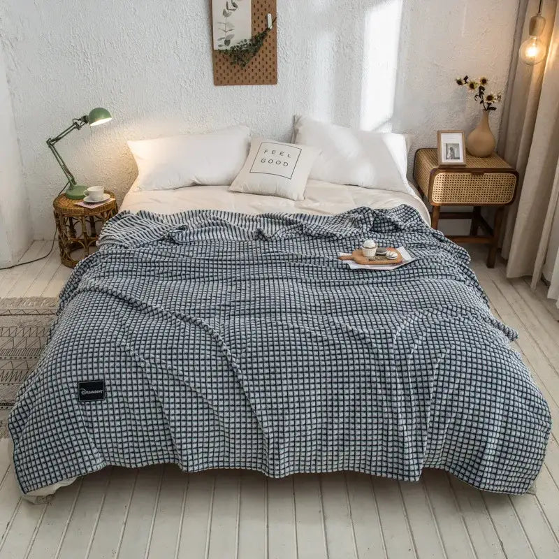 Blue and white checkered quilted blanket with soft texture displayed alongside gray plaid coral fleece bed blanket