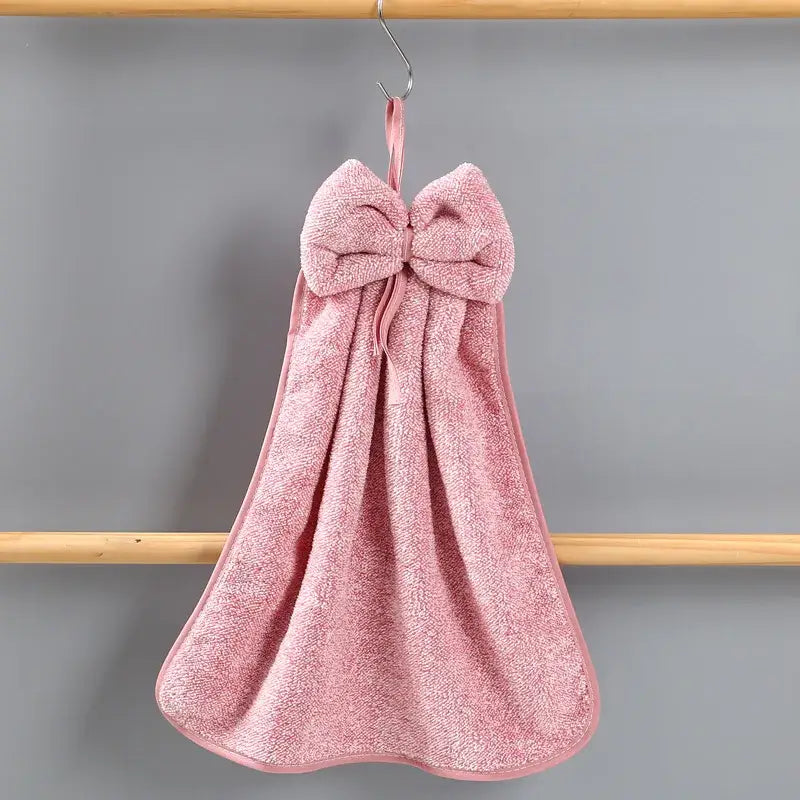 Pink bowknot coral velvet hand towel by decorbites hanging from a hook for kitchen cleaning use