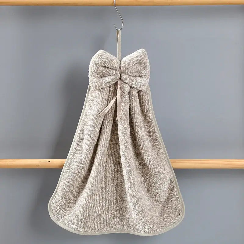 Beige terry cloth hand towel with bowknot coral velvet hanging from hook from decorbites bowknot coral collection