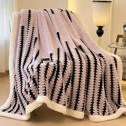 A plush pink and black striped decorbites jacquard blanket with a cozy white fleece border for living room use