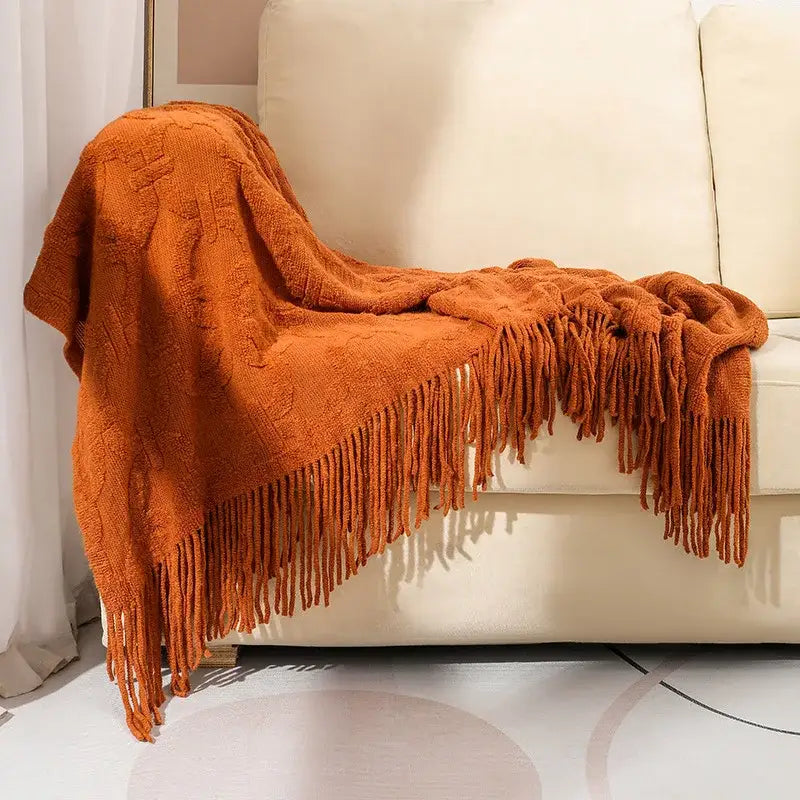 Warm orange knit blanket with textured cable pattern and long fringe for knit blanket sofa decorbites knit blanket decor