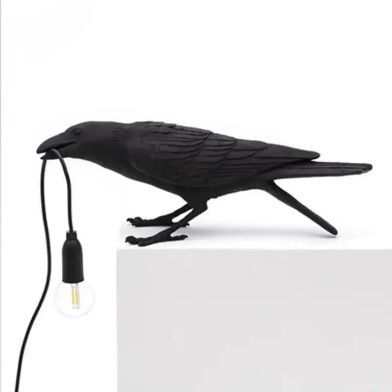 Black crow-shaped bird resin table lamp with matte finish and feather texture holding exposed bulb for bedroom decorbites lively bird